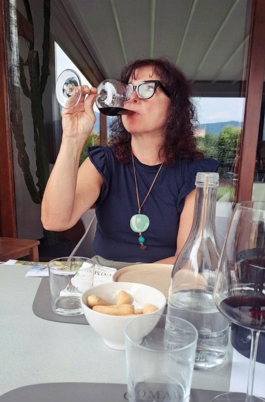 fotografa che sorseggia vino rosso in degustazione